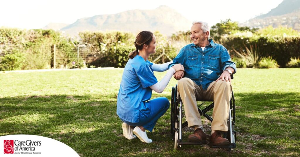 Caregivers like this one talking to a smiling senior patiently and compassionately help clients and help them with aging in place while dealing with different conditions.