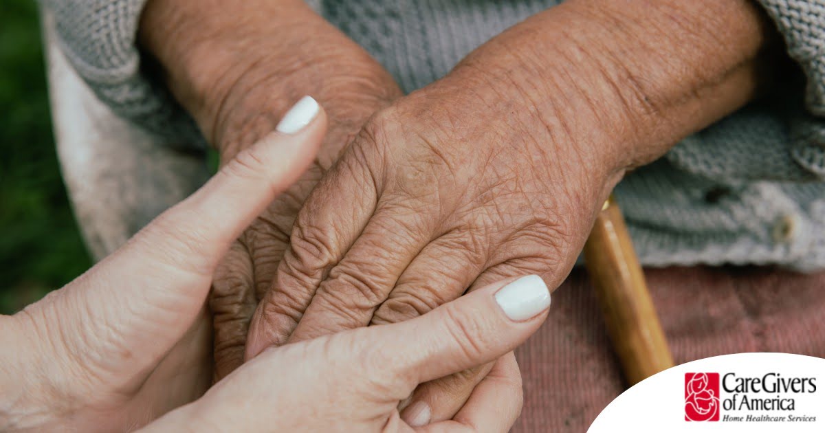 A caregiver holding an older adult's hands represents the support that hospice care can bring.