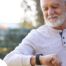 A senior man wears a smart watch, representing one of the many ways smart technology is shaping home health care.