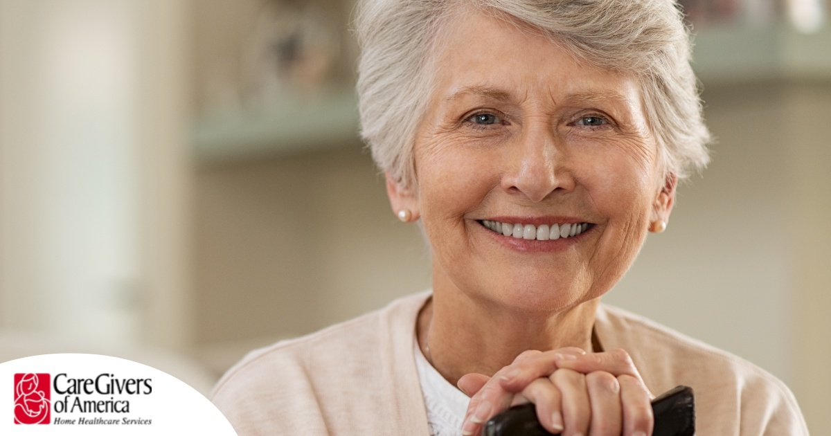 An older woman with healthy teeth smiles, representing good dental hygiene.