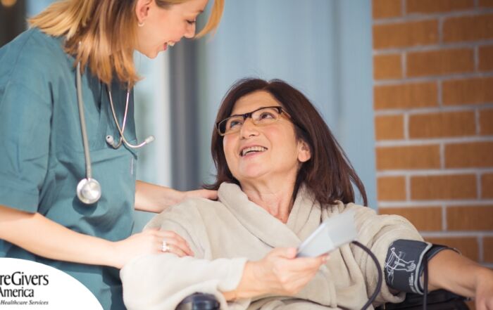 A happy home nurse helps a smiling patient in a wheelchair, representing how home health can help with pain management.