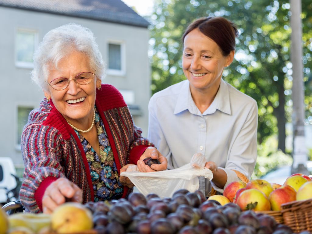 A care giver assists an elderly woman grocery's.