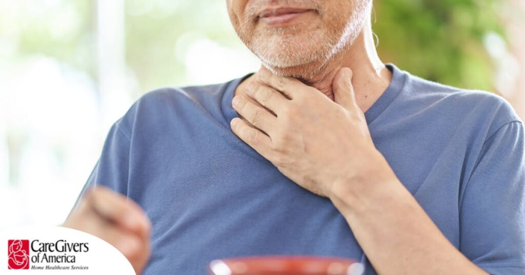 An older adult holds his throat representing dysphagia which can affect senior health.