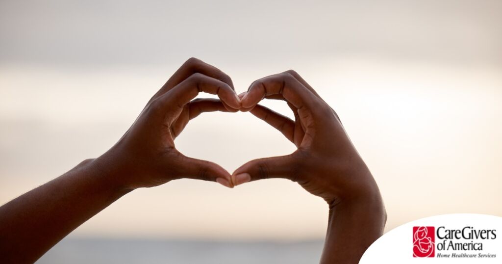 2 hands making a heart represent self-care, a vital concept to appreciate as a caregiver.