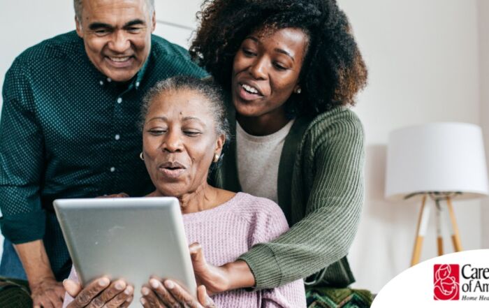 A daughter looks at a tablet with her older parents, representing technology and how ti can help with aging in place.