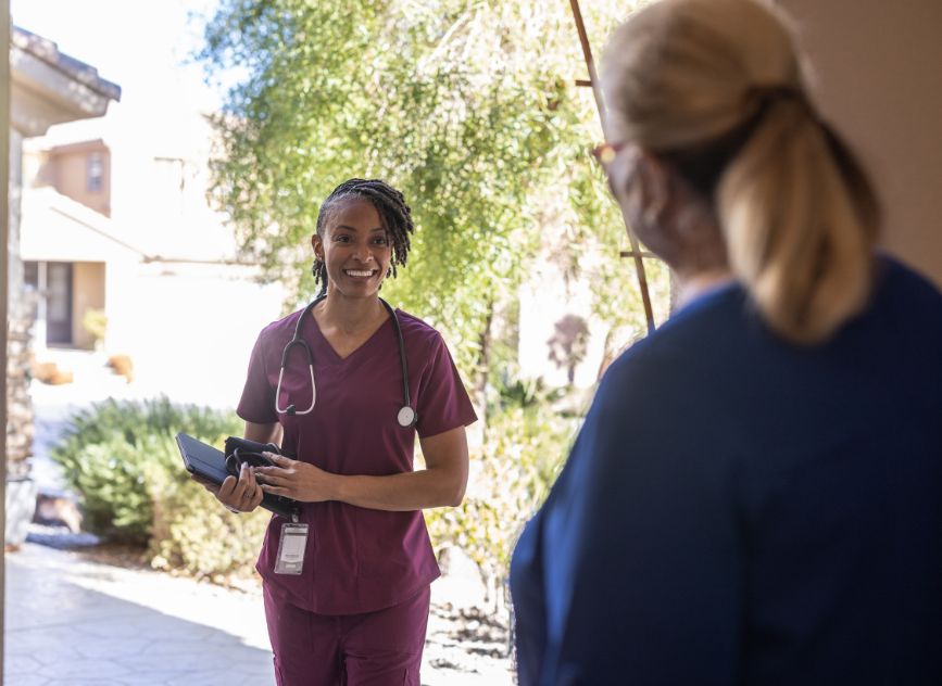 Home health nurse at door of elderly woman
