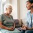 A caregiver sits and spends time with a client, representing how non-medical home care can benefit older loved ones.