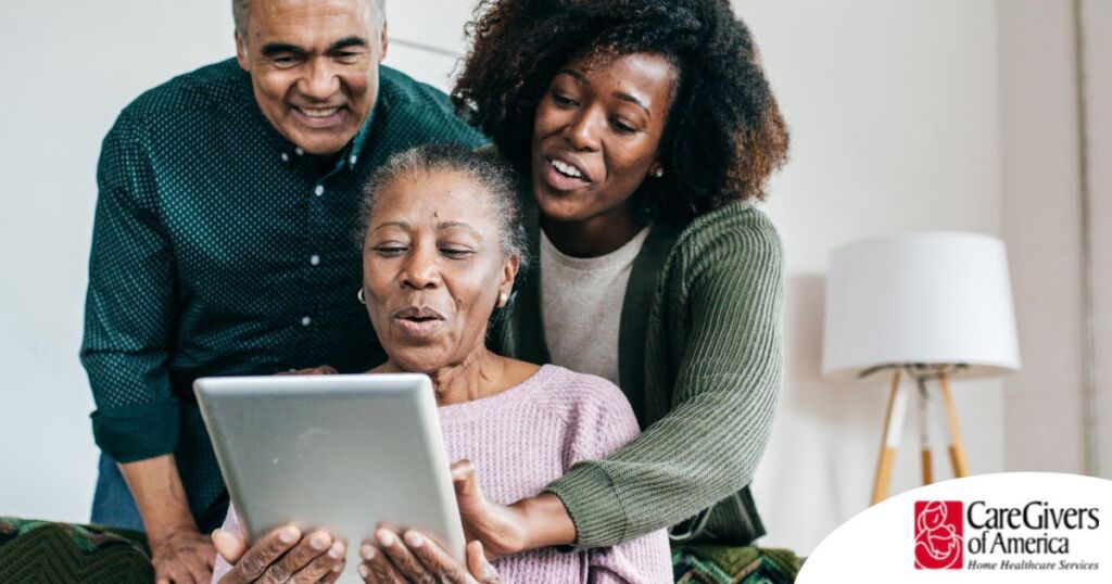 A daughter looks at a tablet with her older parents, representing technology and how it can help with aging in place.