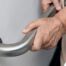 An older adult uses a grab bar representing one of the home modifications that is helpful for fall prevention for elderly adults.