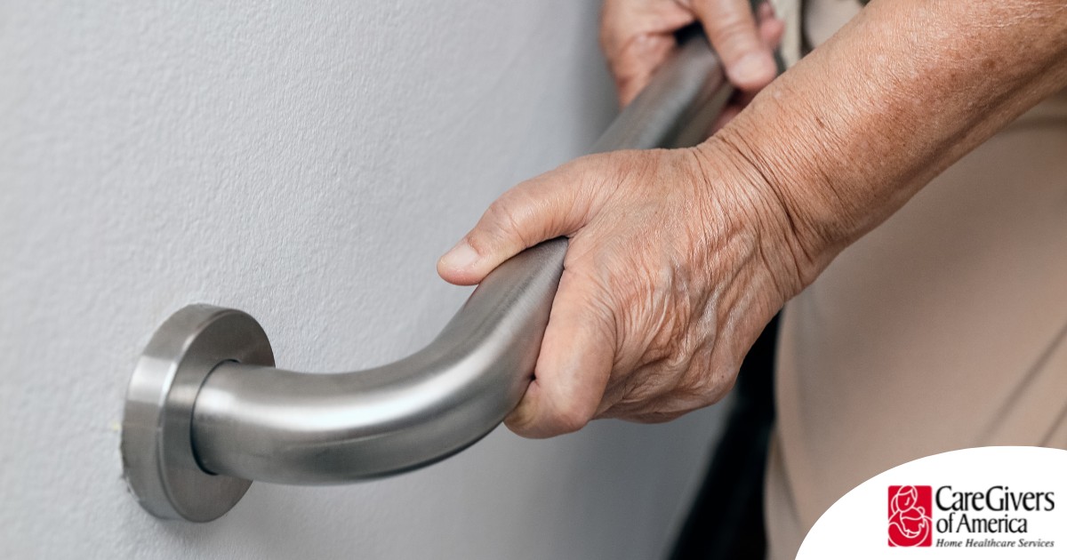 An older adult uses a grab bar representing one of the home modifications that is helpful for fall prevention for elderly adults.