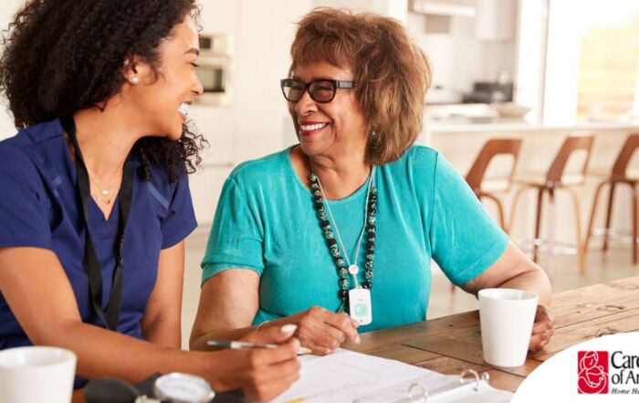 A care provider smiles with an older patient, representing the good results of speech therapy.