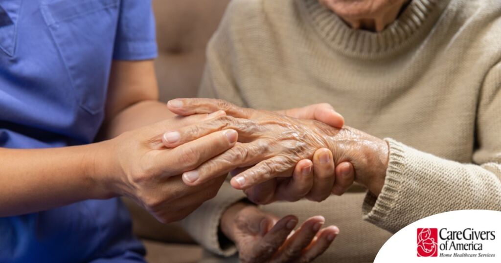 A care provider examines an older adult’s fingers, representing what would happen in an examination for rheumatoid arthritis.
