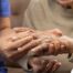 A care provider examines an older adult’s fingers, representing what would happen in an examination for rheumatoid arthritis.