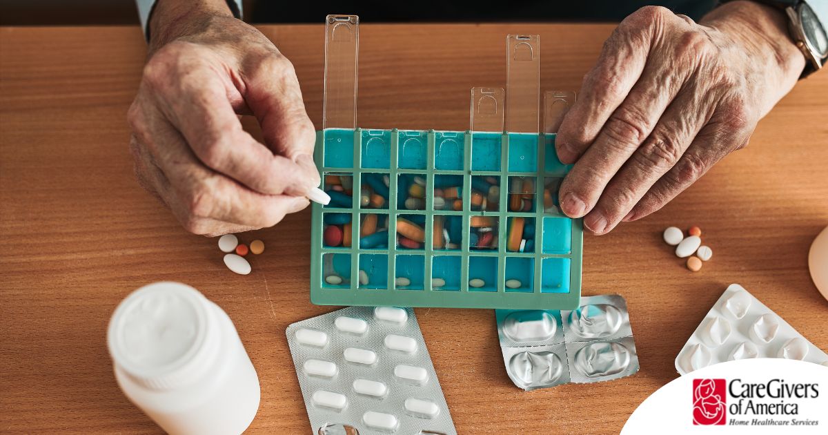 Older hands organize pills into a pill organizer, showing a great tool for managing medications.