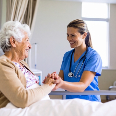 Smiling nurse holding hands with a senior woman in Miami Beach, offering companionship and care.