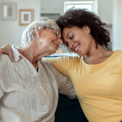 Family caregiver sharing a warm moment with an elderly woman at home, representing compassionate respite care services.