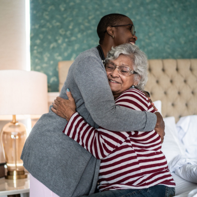 caregiver hugging elderly woman at home through GUIDE dementia program Florida