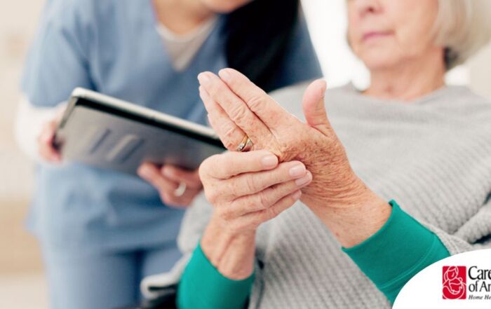 A caregiver providing in home care services to help manage a senior with arthritis