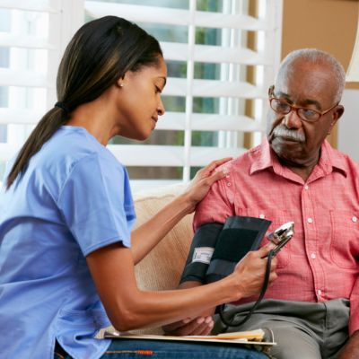 Caregiver checking an older adult's blood pressure during Stroke Care in Margate.