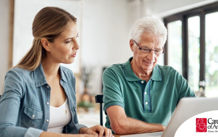 Adult daughter and senior father talking at a kitchen table while comparing home care vs assisted living